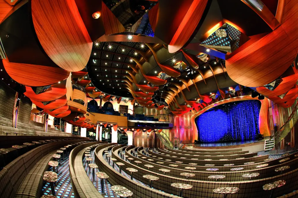 Modernes Theater mit beleuchteter Bühne und geschwungenen Sitzreihen an Bord der Costa Deliziosa bei Captain Cruise